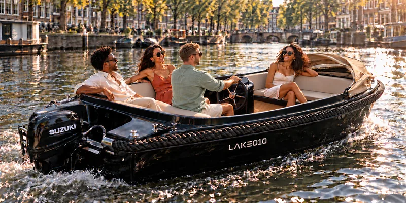 Sfeerbeeld van gezelschap in de Deluxe langs een zonnige kade